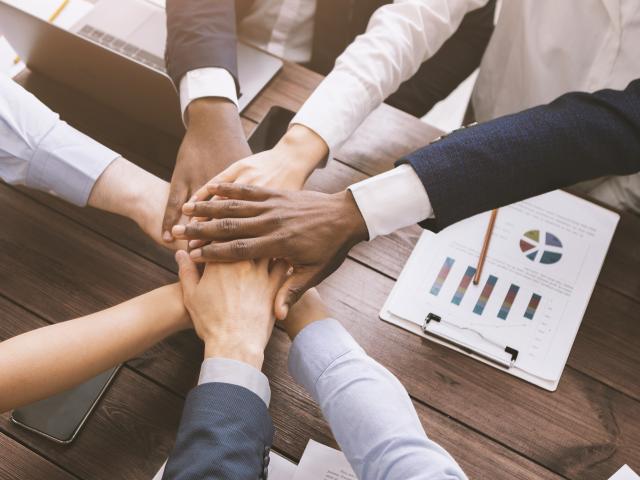 Business collaboration. Top view on diverse corporate team hands stacked together in office, top view